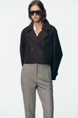 Pantalón blanco de vestir, de tiro alto y corte recto. Presenta bolsillos delanteros de vivo y cierre frontal con cremallera, botón interior y gancho metálico.