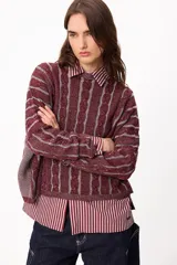 Sweater de punto con diseño de rayas verticales en relieve y textura trenzada, color terracota y beige. Presenta cuello redondo, corte holgado y diseño cropped.