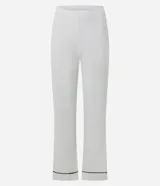 Pijama de dos piezas confeccionado en tejido ribana, compuesto por una blusa de manga larga con escote en V y cuello tipo polo, y un pantalón de corte recto. Ambas prendas presentan un diseño liso en color blanco con detalles de biés en contraste color negro en el cuello, puños y ruedo.