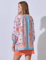 Blusa de gasa estampada con flores, cuello redondo y abertura central con botones. Manga ¾ con puño elastizado.
