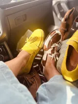 Alpargatas tipo mocasín de gamuza color amarillo mostaza, con detalle de flecos en la capellada.