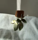 Aros colgantes hechos a mano en bronce con forma de hojas.