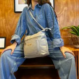 Bandolera color bordó de símil cuero con dos bolsillos frontales con cierre, un bolsillo trasero y tres bolsillos internos. Incluye correa larga regulable a tono.