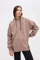 Canguro oversize de felpa con friza, color marrón. Presenta capucha forrada con cordones ajustables, cortes en el cuerpo y tajos decorativos en el frente.