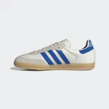 Championes Adidas Samba OG de diseño clásico, con parte superior de cuero blanco, superposiciones de gamuza gris claro en la puntera y el área de los cordones, y las icónicas tres rayas en azul vibrante. Presenta un detalle de tejido acanalado azul en el talón y suela de goma color caramelo.