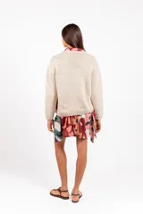 Sweater de lana merino color beige, tejido a mano con diseño holgado, cuello redondo y bordados artesanales de ranas y detalles coloridos.