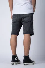 Bermuda de jean color negro lavado, de corte regular y largo a la rodilla, con dobladillo doblado en el ruedo.