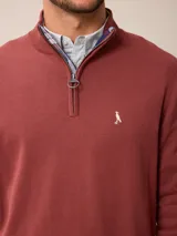 Sweater de punto color gris, con cuello alto y cierre frontal parcial con detalle de tela a cuadros en el interior. Presenta puños y ruedo acanalados y logo bordado en el pecho.