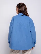 Sobrecamisa color beige de paño con cuello camisero, cierre frontal con botones veteados, dos bolsillos con solapa en el pecho y dos bolsillos laterales.