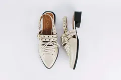 Sueco de cuero color borgoña con cordones, ojales y hebillas plateadas. Tiene tira trasera regulable con elástico.