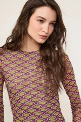 Vestido corto ajustado de manga larga y cuello redondo, confeccionado en tejido semitransparente con estampado geométrico multicolor en tonos fucsia, verde y marrón.