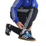 Pantalón deportivo Adidas de la selección argentina, color negro con franjas laterales blancas. Presenta el escudo de la AFA bordado en la pierna derecha y el logo de Adidas Originals en la izquierda. Cuenta con cintura elástica y ajuste cómodo.