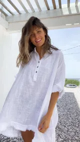 Túnica blanca de lino rústico con cuello henley y botones.