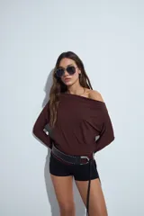 Top de manga larga con escote bote amplio, diseñado para usar ligeramente caído sobre los hombros. Presenta una silueta entallada y tejido liso, liviano y adaptable al cuerpo.