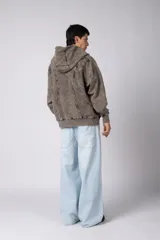 Campera oversize con capucha y cierre frontal, confeccionada en tela con acabado acid wash que le otorga un aspecto desgastado. Presenta costuras curvas decorativas en el frente y la espalda, puños y ruedo acanalados, y un calce relajado.