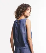 Blusa musculosa de jean color celeste, con cuello redondo y cierre posterior con botón. Confeccionada en una mezcla de lyocell y algodón, presenta un diseño sin mangas y corte recto.