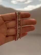 Set de pulseras elásticas compuestas por hileras de strass en tonos rojo, plateado y rosado.