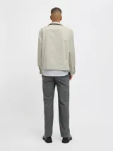 Campera aviadora color beige, de corte clásico, con cuello camisero, cierre frontal con cremallera, bolsillos laterales y puños elastizados.