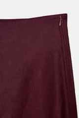 Falda midi de tiro alto color bordó, confeccionada en 100% lino, con corte en A y cierre lateral oculto.
