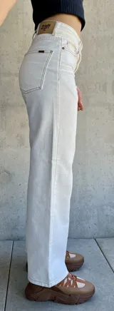 Pantalón jean de tiro alto color blanco, corte recto y pierna ancha.