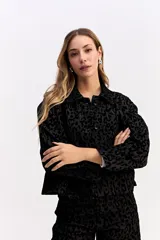 Campera de corte clásico con cuello camisero y cierre frontal de botones, confeccionada en tejido de algodón con textura en relieve de animal print.