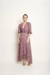 Vestido largo con estampado floreado en tonos rosados, escote en V cruzado y mangas cortas abullonadas.