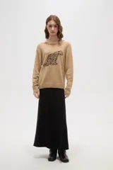 Sweater de tejido de punto color beige con estampado jacquard de leopardo en color negro. Presenta cuello redondo amplio y puños y ruedo acanalados.