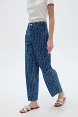 Pantalón jean azul de tiro bajo y corte ancho, con estampado de rayas verticales y diseño floral sutil.