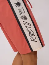 Short de baño color verde menta con cordón de ajuste en la cintura y una franja lateral con diseño de rayas en negro y blanco.