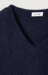 Sweater de punto fino color azul marino, con cuello redondo amplio y mangas largas con puños rectos. Presenta un corte holgado y diseño minimalista.