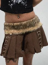 Pollera mini de tiro bajo color marrón, con diseño plisado y detalles de cordones laterales con ojales metálicos. Presenta una banda de piel sintética removible en la cintura.