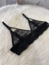 Conjunto de lencería compuesto por bralette triangular, tanga y portaligas, confeccionado íntegramente en encaje negro con detalles de breteles regulables.