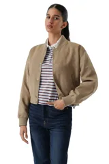 Campera tipo bomber de corte cropped, confeccionada en microgamuza color tostado. Presenta cierre frontal con botones a presión metálicos, cuello redondo y puños elásticos acanalados.