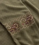 Blusa de viscosa color verde oliva, con cuello redondo, lazo con borlas decorativas y mangas largas con bordado étnico en los puños.