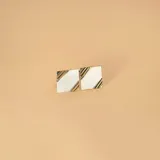 Gemelos de forma cuadrada con acabado cepillado, combinando plata y detalles en oro en las esquinas opuestas.