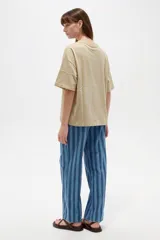 Remera oversize de algodón color gris oscuro, con cuello redondo, mangas cortas y estampado lateral en tonos claros de cadenas y una llave.