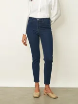 Jean de corte skinny en color azul oscuro, con tiro medio y cierre frontal con botón y cremallera.