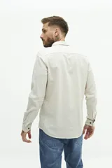 Camisa de manga larga color beige claro, confeccionada en una mezcla de lino y algodón. Presenta un corte semi slim, cuello camisero y un pequeño logo bordado en el pecho.