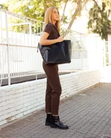 Botinetas de cuero negro con paneles laterales de gamuza al tono. Presentan una suela track robusta con taco cuadrado y cierre lateral para facilitar el calce.