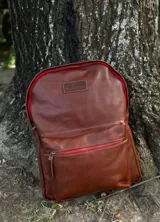 Mochila de cuero color marrón, forrada en lino, con cierres de bronce y un compartimento interno para computadora.