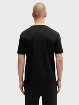 Camiseta negra de manga corta y cuello redondo, con un gráfico abstracto en blanco y negro con textura desgastada en el centro del pecho, y el logo 'BOSS' en la parte inferior izquierda del gráfico.