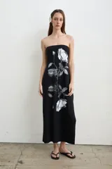 Vestido largo negro de algodón sin tirantes con escote palabra de honor, estampado de rosas blancas y aberturas laterales.