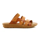Sandalias de cuero color suela y marrón, con diseño de tres tiras cruzadas en el empeine y tira ajustable con velcro en el talón. Cuenta con suela plana y cómoda.