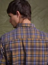 Camisa de pana color azul marino, con mangas largas, cuello clásico y dos bolsillos frontales con solapa y botón.