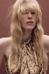 Top de cuello halter con diseño sin mangas, confeccionado en tela fluida con estampado de manchas abstractas. Presenta un cierre en la espalda con abertura y botones.
