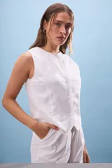 Musculosa blanca de lino con cuello redondo y abotonadura frontal.