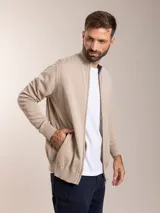 Campera color beige de tejido de punto con cierre frontal y cuello alto.