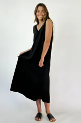 Vestido midi negro sin mangas, con escote en V y ribete blanco en el cuello y las sisas.