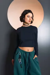 Top de manga larga color negro, con cuello redondo y costuras decorativas verticales en el frente. Presenta un corte ajustado y estilo cropped.