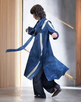 Tapado largo de lana merino afieltrada, color fucsia con diseño tie-dye artesanal en tonos claros y crudos. Tiene cuello que se prolonga a modo de cinto, aberturas laterales y bolsillos.